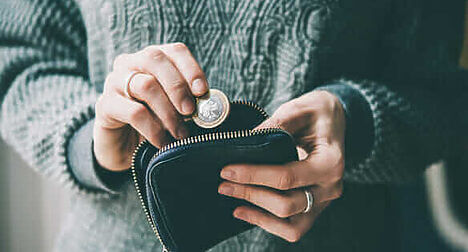 photo of person holding wallet with cash