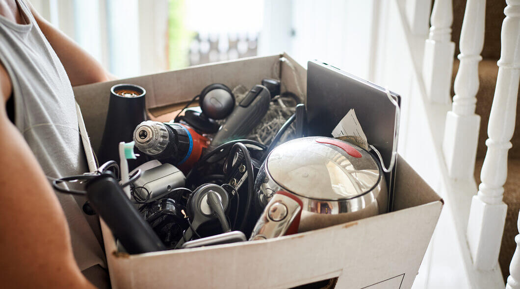 girl holding box of old electricals