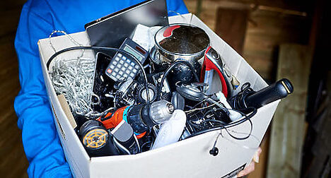 photo of person holding box of old electrical items