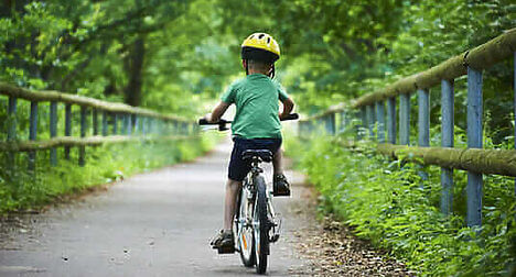 child on bike in country lane