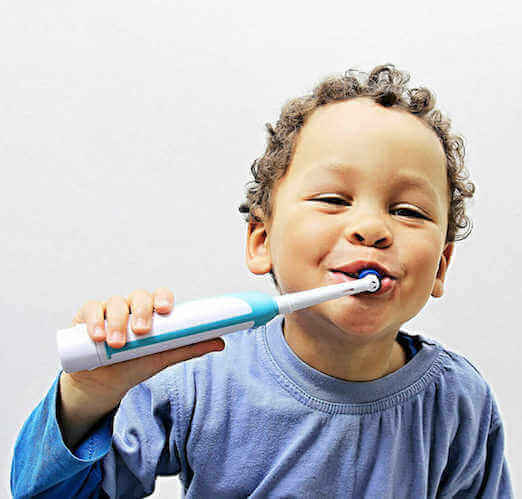 child using electrical toothbrush