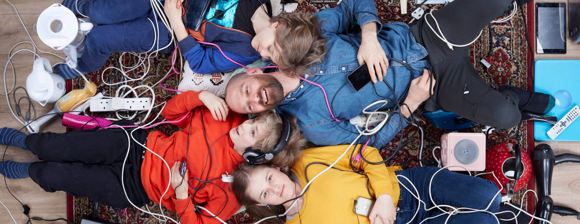 Family lying in a pile of old electrical items