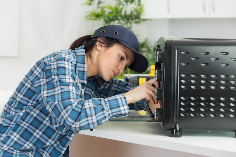 woman repairing microwave oven