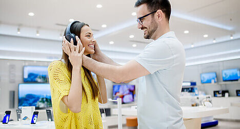 people testing headphones in store