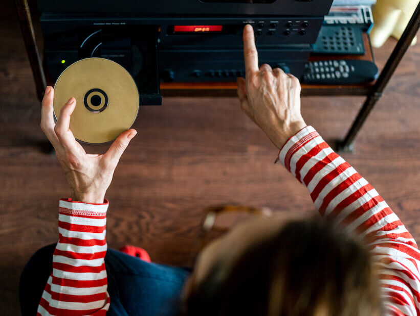 woman loading CD/DVD into player