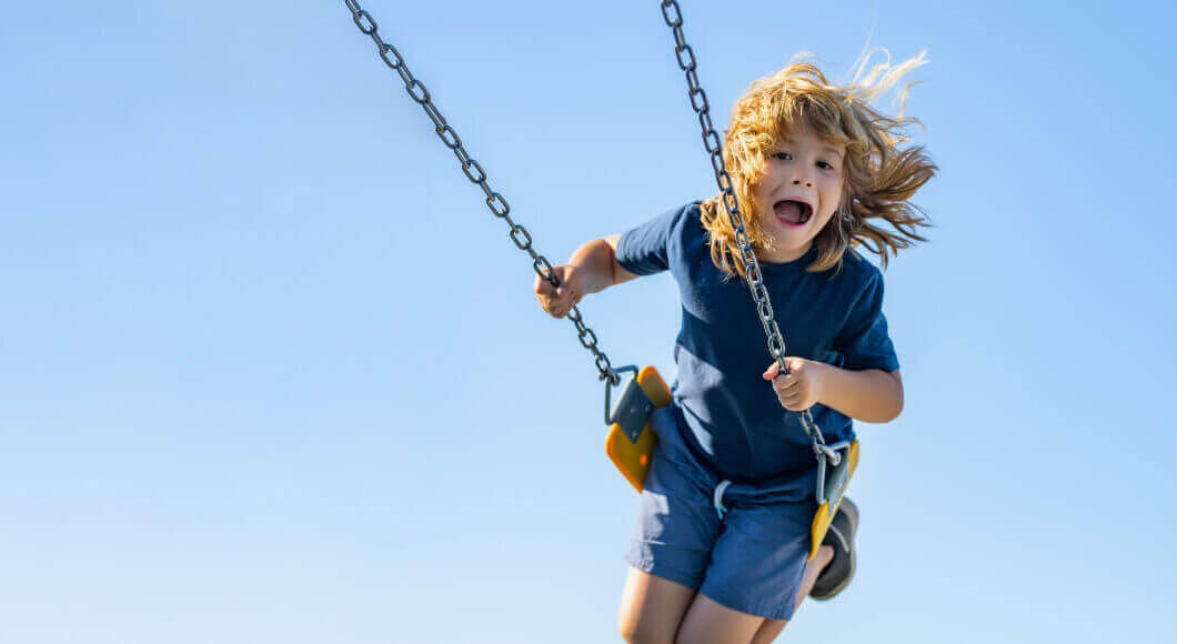 child on a swing laughing