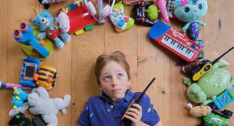 child with walkie talkie and other electrical toys