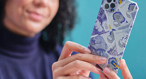 woman holding phone in origami bank notes