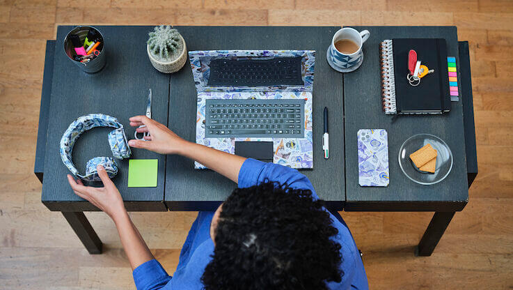 person at desk with electrical items made from origami bank notes