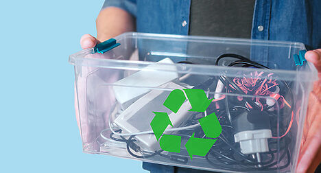 person holding a see-through plastic box of old cables