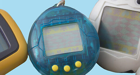 a close up of a blue electronic tamagotchi toy