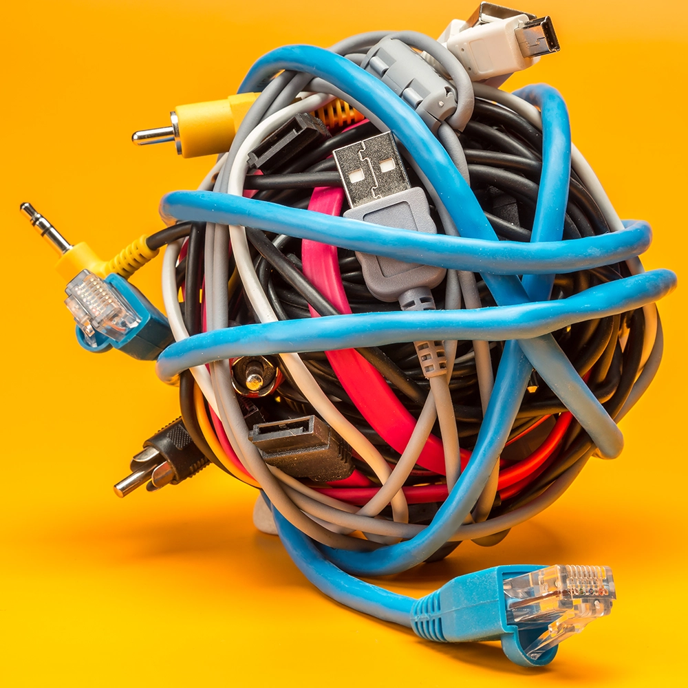 a close up of a ball of various electrical cables on a yellow background