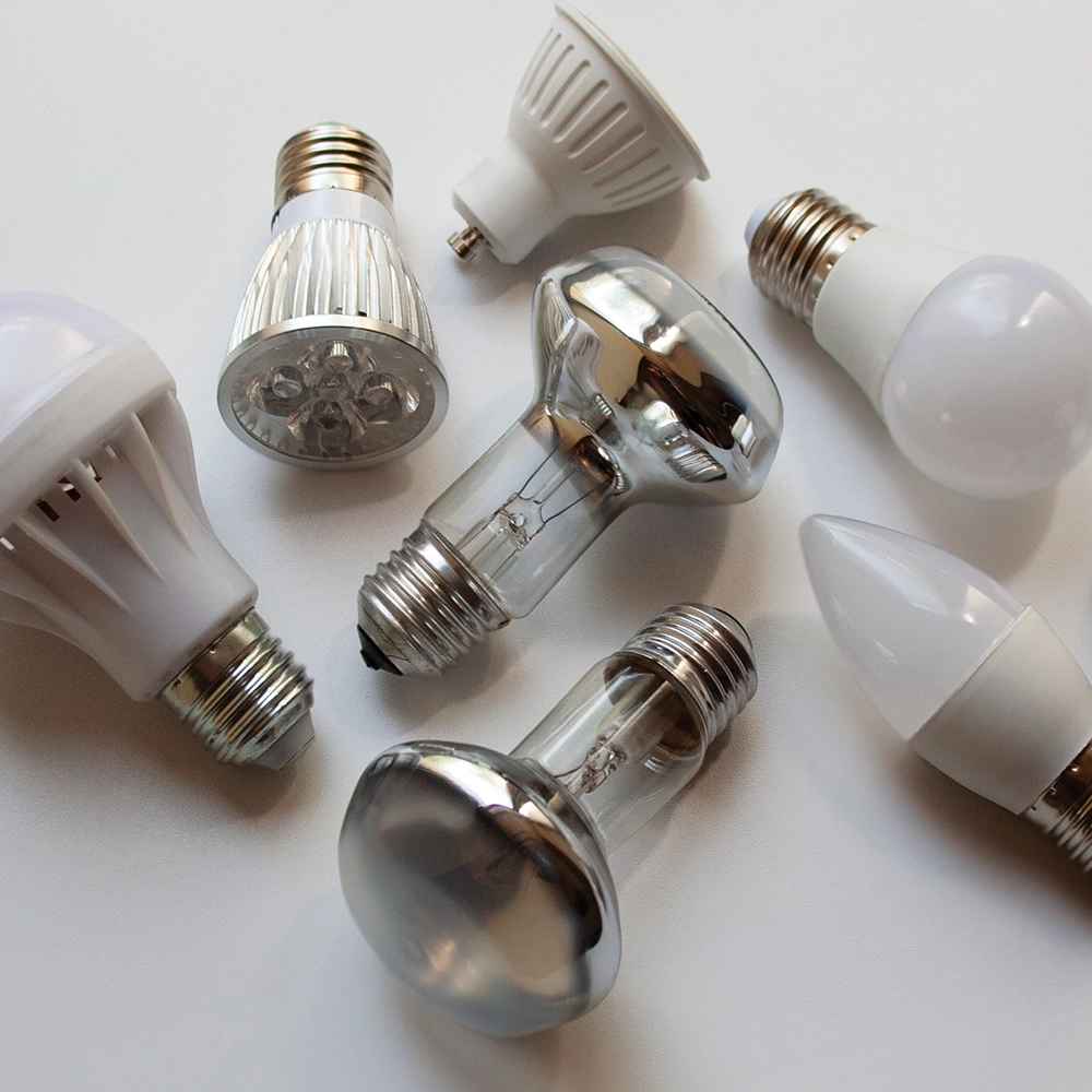 a collection of various types of lightbulb on a white table.