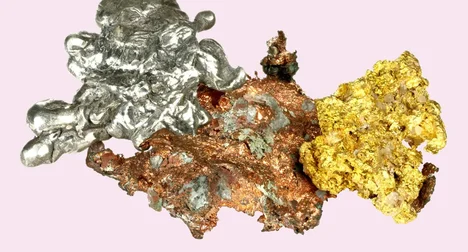 various molten precious metals next to each other in uneven blobs on a pink background