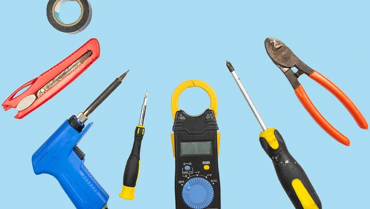 various electrical repair hand tools on a blue background