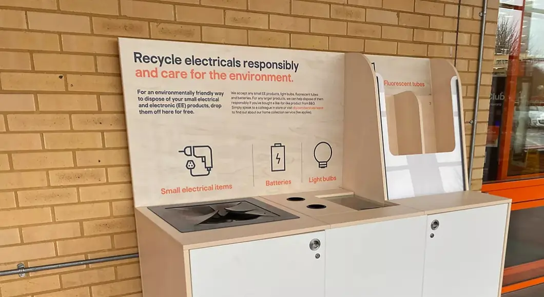 White and plywood electrical drop off point outside of a homeware shop, text on the bin reads: Recycle electricals responsibly and care for the environment.