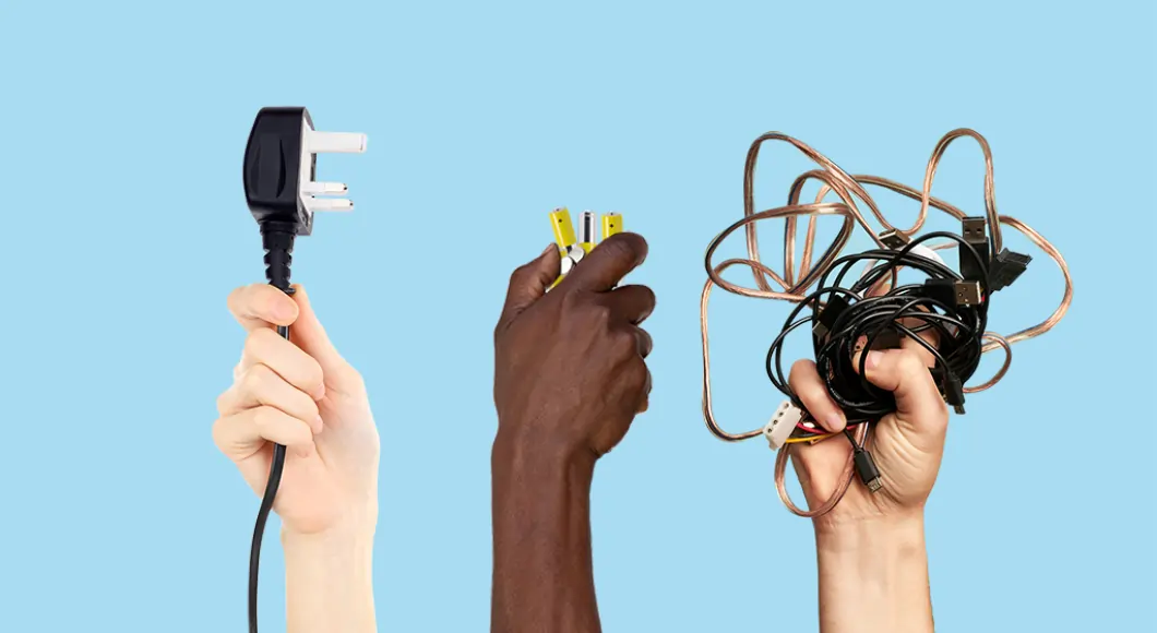 a pale skinned hand holding a plug a dark skinned hand holding some batteries and a pale skinned hand holding some cables on a blue background