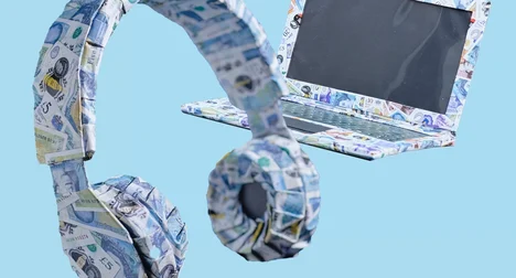Laptop and headphone wrapped in £5, £10 and £20 notes, floating against a bright blue backdrop.
